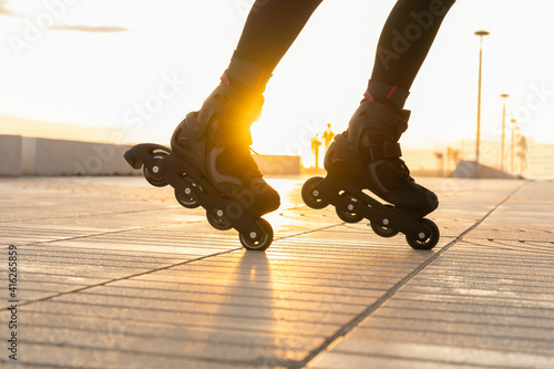 Closeup view of woman legs with roller skates at sunset.Creative sport and roller skating lifestyle concept on sunny day.
