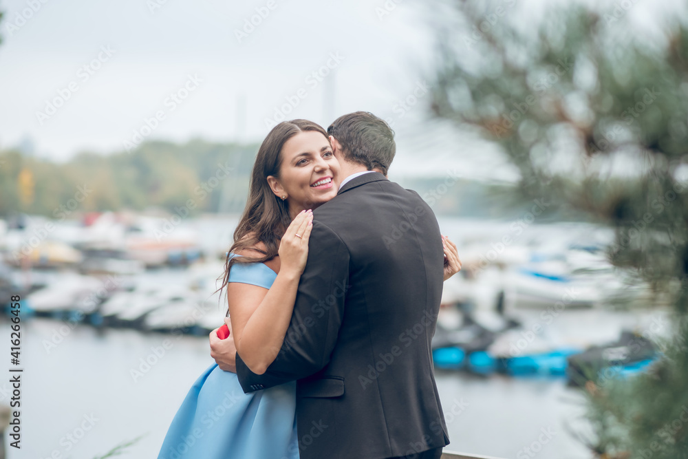 Man hugging beautiful smiling woman in street Man hugging beautiful smiling woman in street