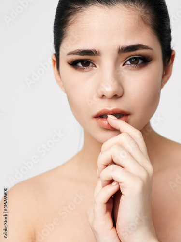 pretty brunette naked shoulders emotions hand near face close up