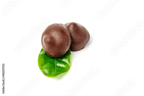 Chocolate candies decorated with a green leaf isolated on a white