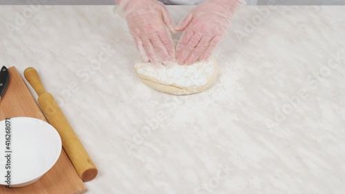 Close-up, woman hands kneading dough on the table. Tight dough for dumplings.