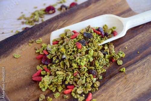 Homemade Matcha green tea granola with goji berry, dried cranberry, raisin, sesame seeds and almond nuts photo