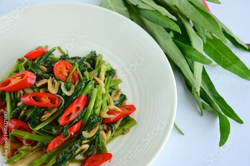 Stir fried Water Spinach or Kangkung with fried Anchovies and Quail eggs. One of the famous Indonesian cuisine. photo