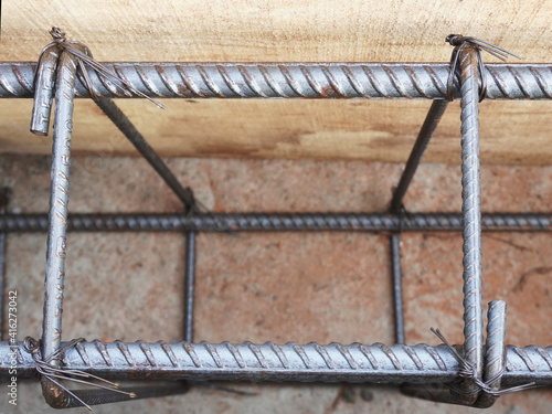 Reinforced bar (rebar). TMT steel rods tied together forming the core of concrete, enclosed in wooden mold.
