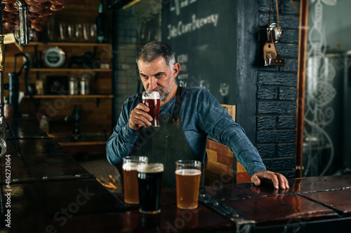 bartender working in bar. he is testing craft beer