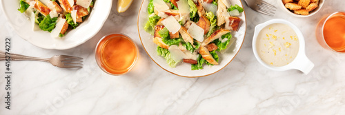Caesar salad panorama with copy space  a flat lay with sauce and wine