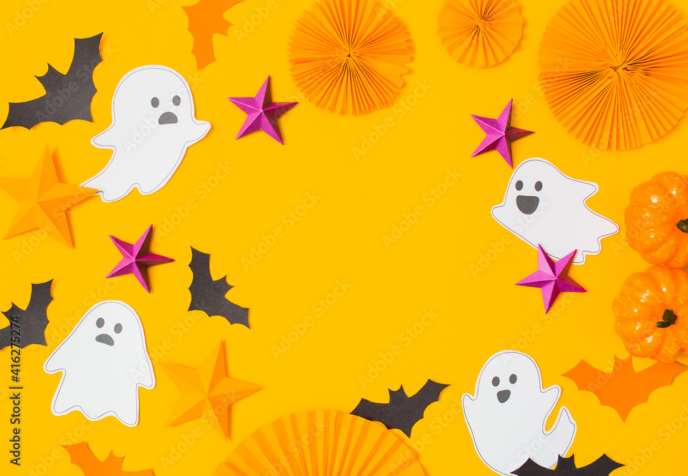 Fototapeta premium Halloween paper craft flat lay.Children seasonal art table top view.Kids hand craft concept.Bright halloween background with cutted out ghosts and paper crafts.