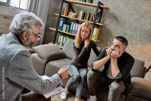 Psychotherapist talking to man during appointment in cabinet