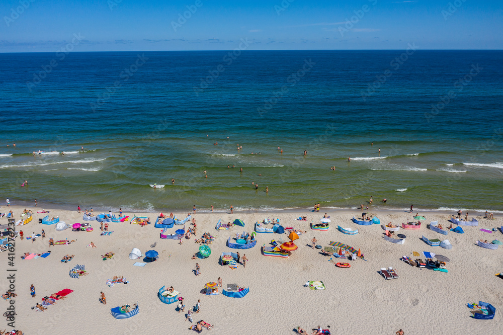 Sunbathing on the beach by the sea. Aerial drone view of  Baltic Sea coast in Hel peninsula, Jastarnia. Puck Bay in Poland