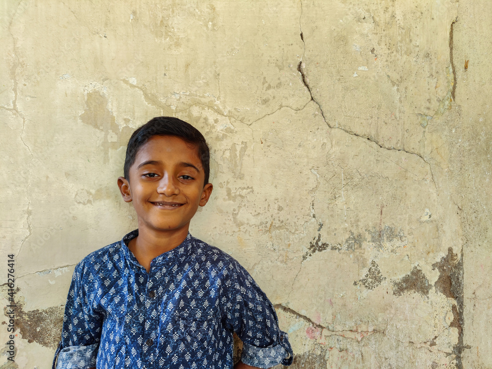 Portrait of Indian boy smiling and posing in front of blank wall. Portrait of Indian boy smiling and posing in front of blank wall.