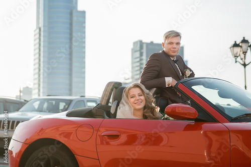 happy bride and groom sitting in a luxury car.