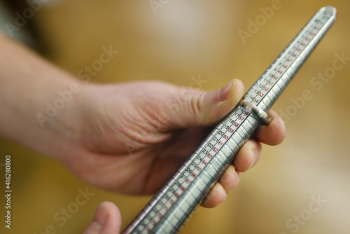 Goldsmith's hand measuring the size of a ring using a ring mandrel.