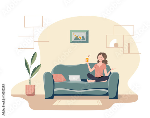 Happy cartoon girl with the glass of orange juice calls on a laptop. Nice young woman sitting on a sofa in her cozy living room. Modern home interior.