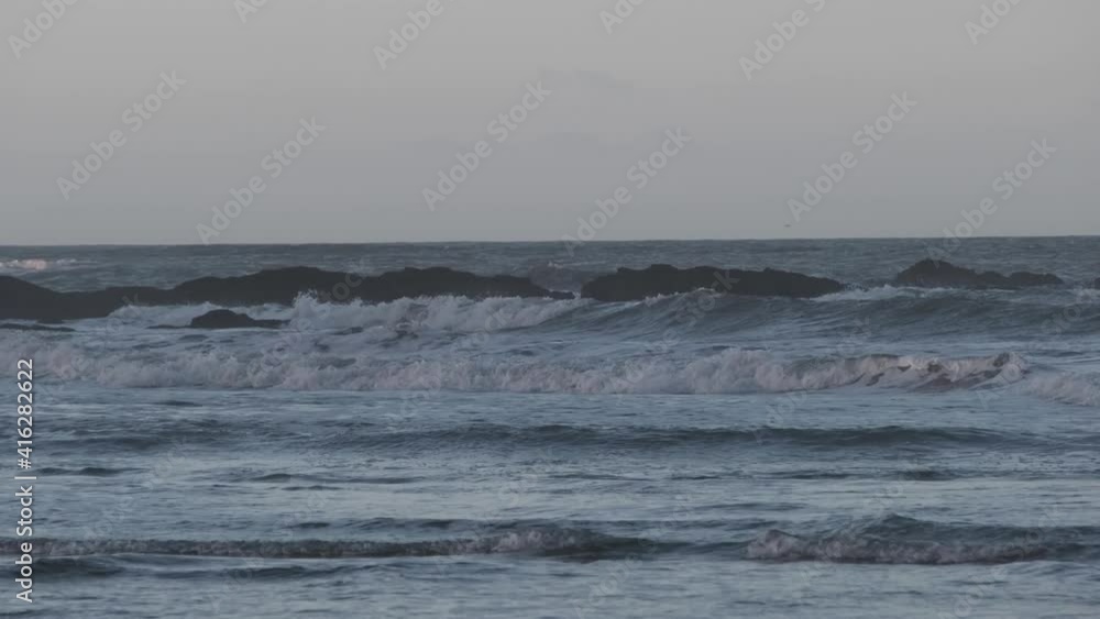 Early morning with tidal waves crashing on rocks and beach, cinematic footage. Handheld camera Early morning with tidal waves crashing on rocks and beach, cinematic footage. Handheld camera