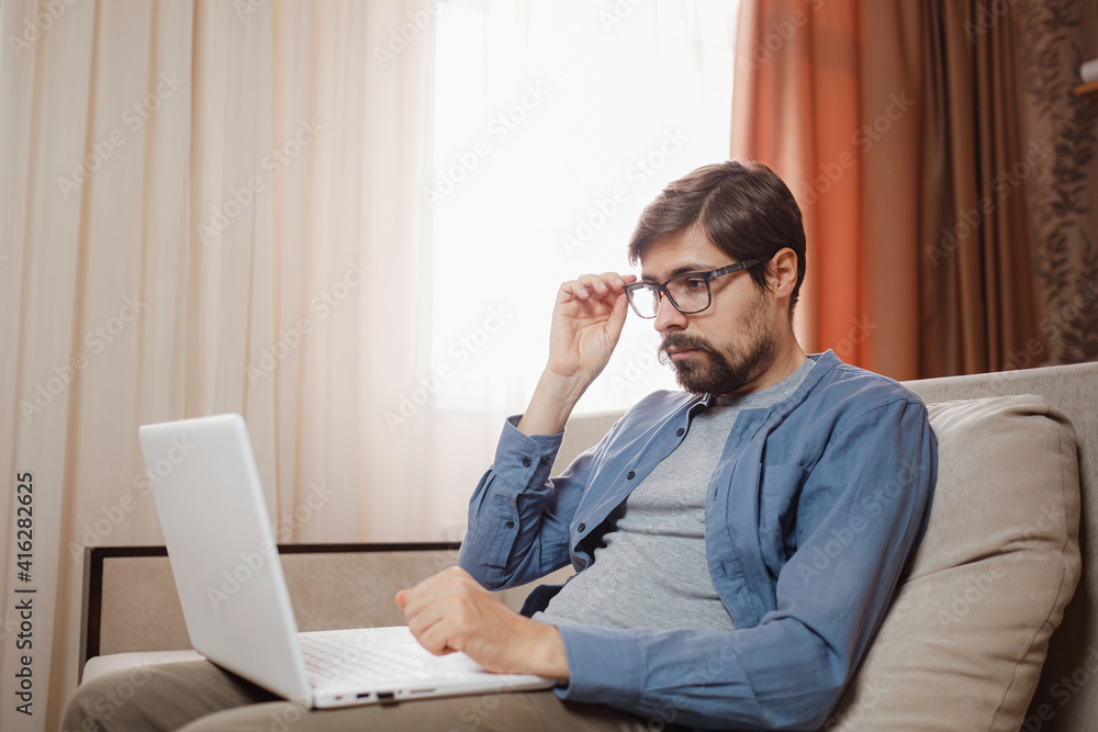 Handsome young man using laptop computer at home. Handsome young man using laptop computer at home.