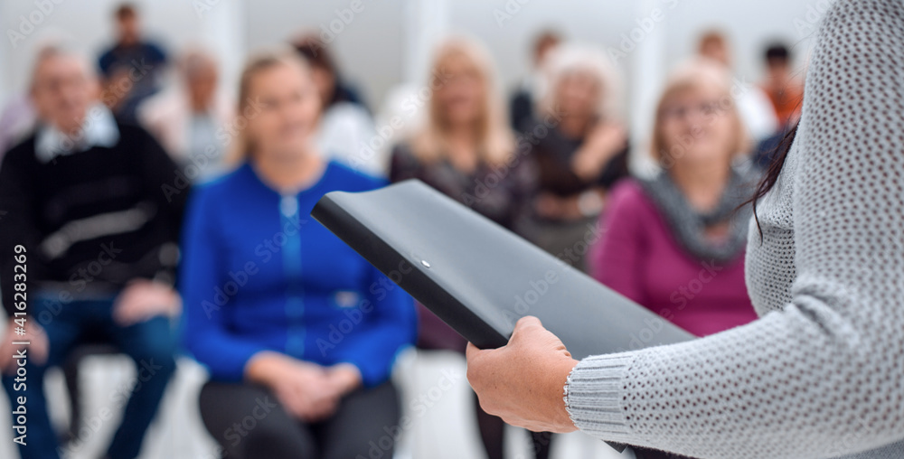 © ASDF - teacher with a folder in his hand teaches elderly people busines