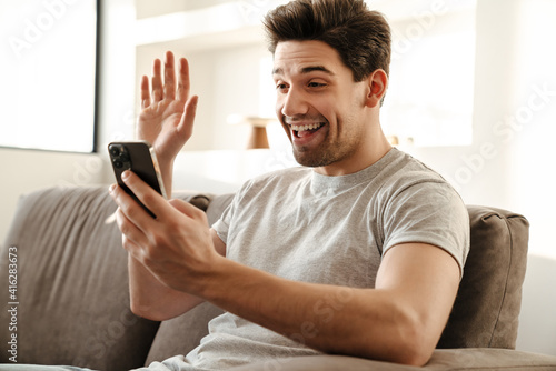 Happy man with smartphone having video call