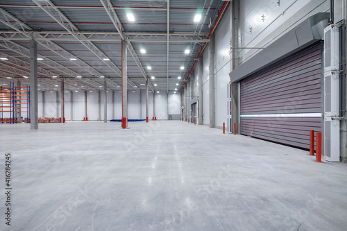 warehouse or hangar. Industrial building interior consist of polished concrete floor and closed door for product display or industry background.