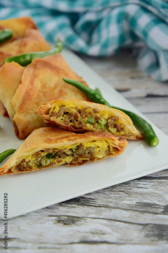 Homemade Martabak Telur, Indonesian cuisine. Pan-fried wrap filled with ground beef, egg and scallion. Served with green chilli Rawit