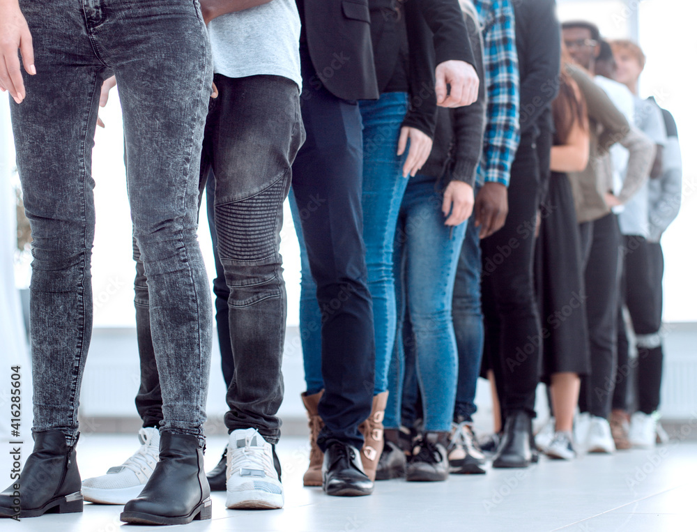 group of diverse young people standing in a queue.