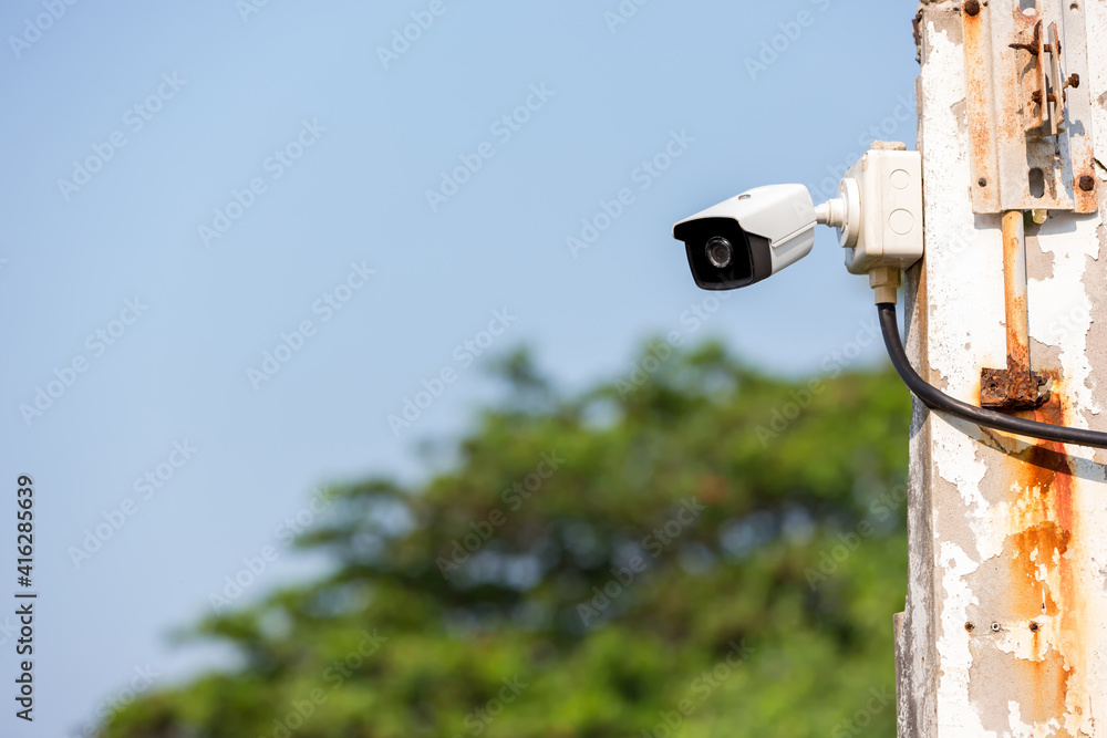 Online Security CCTV camera surveillance system outdoor of house. A blurred  night city scape background. Real time Modern CCTV camera on a wall.  Equipment system service for safety life or asset. Stock