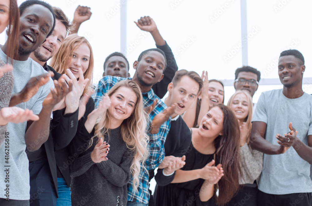 group of diverse young people are applauding while looking at you group of diverse young people are applauding while looking at you