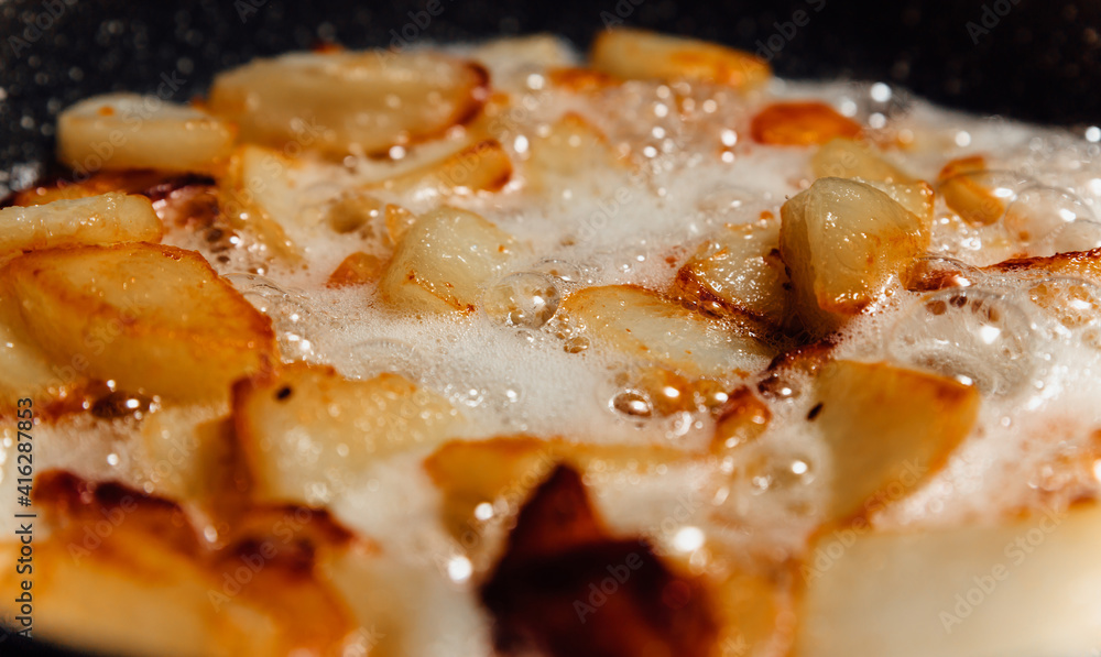 Chunks of potatoes are fried in boiling oil. Close-up photo of cooking junk food. Chunks of potatoes are fried in boiling oil. Close-up photo of cooking junk food.
