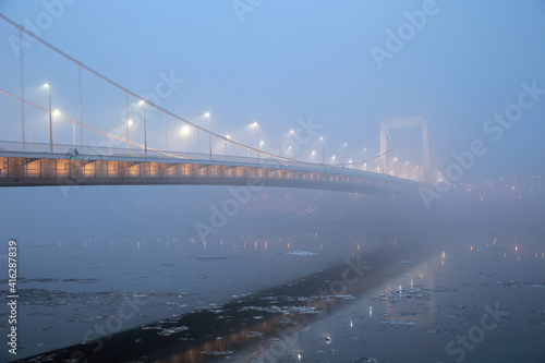 Elizabeth Bridge in mysterious fog over the icy Danube in Budapest, Hungary; color photo