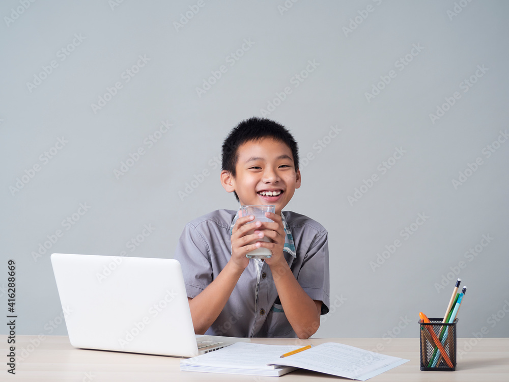 Little boy doing homework and drinking milk Little boy doing homework and drinking milk