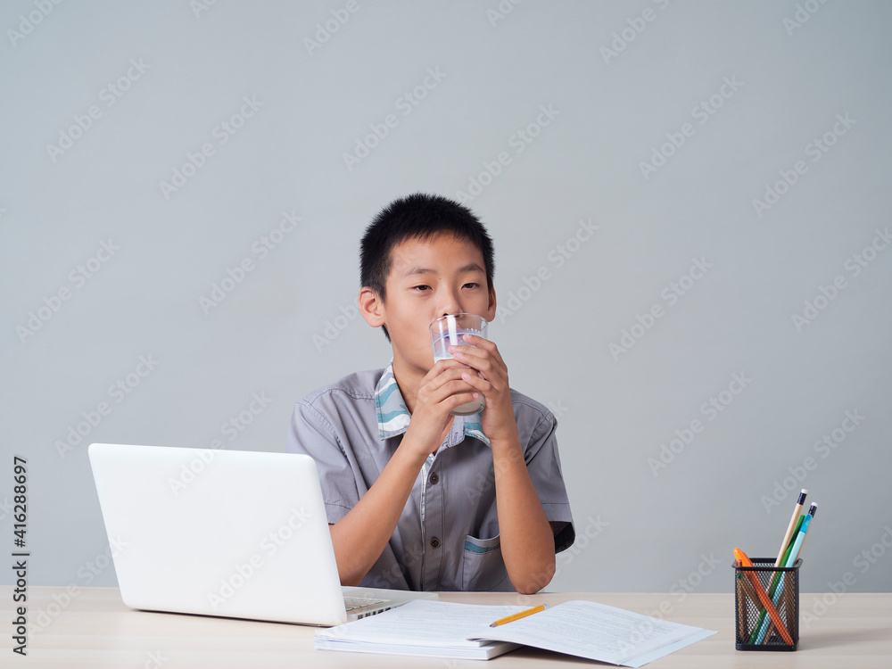 Little boy doing homework and drinking milk Little boy doing homework and drinking milk