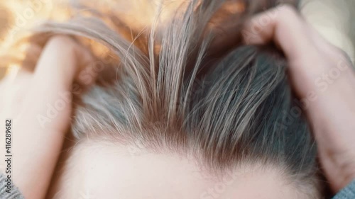 Men slides his hands through his hair multiple times during golden hour