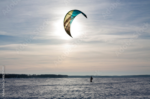 Horizontal outdoor sports photo with a lone man ski kiter skydiving in a strong wind in the winter daytime