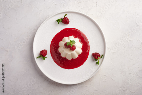 Foto Panna cotta with raspberry syrup, pistachios, berries and mint, high key, top vi