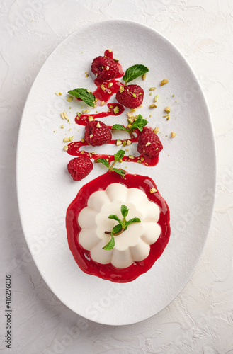 Foto Vertical orientation panna cotta with raspberry syrup, pistachios, berries and m