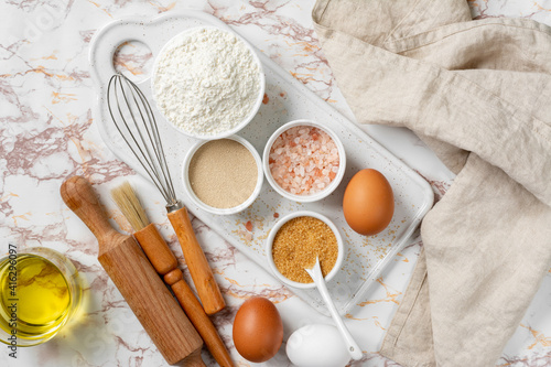Ingredients for baking on a culinary background. Eggs, flour, dry yeast, sugar, salt on the kitchen table. The concept of preparation for yeast baking. Top view 