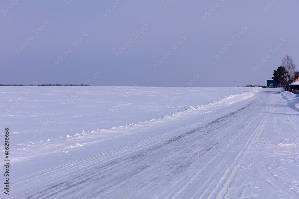 road leading to the village through the snow plain