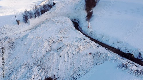 Road leads through an avalanche of snow. The avalanche was removed with large machines so that the road is passable again. It is still a great danger to drive through the road.
