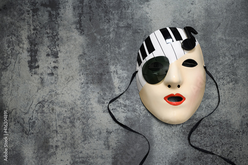 Porcelain mask of a female musical muse on a stone tile