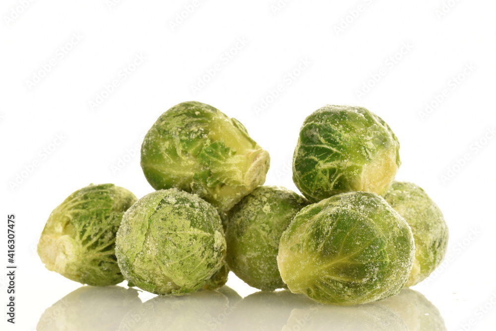 Fototapeta premium Several frozen Brussels sprouts, close-up, isolated on white.
