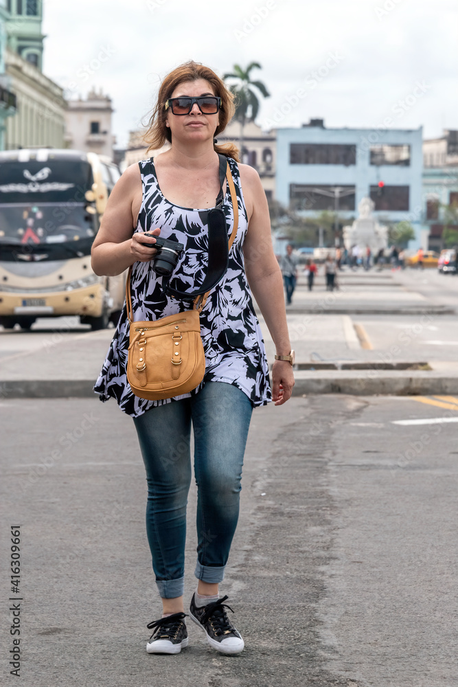 A Hispanic middle-aged woman doing tourism in Havana, Cuba A Hispanic middle-aged woman doing tourism in Havana, Cuba