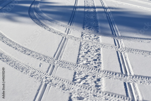 A trace of snowmobile and car tire