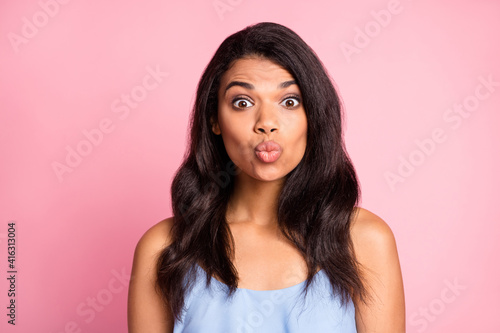 Portrait of optimistic brunette lady blow kiss wear blue top isolated on pastel pink color background
