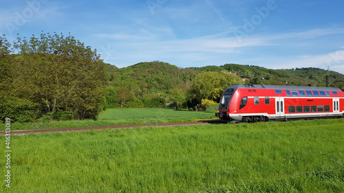Red train Was running through a green meadow. On a bright day. © Pingky