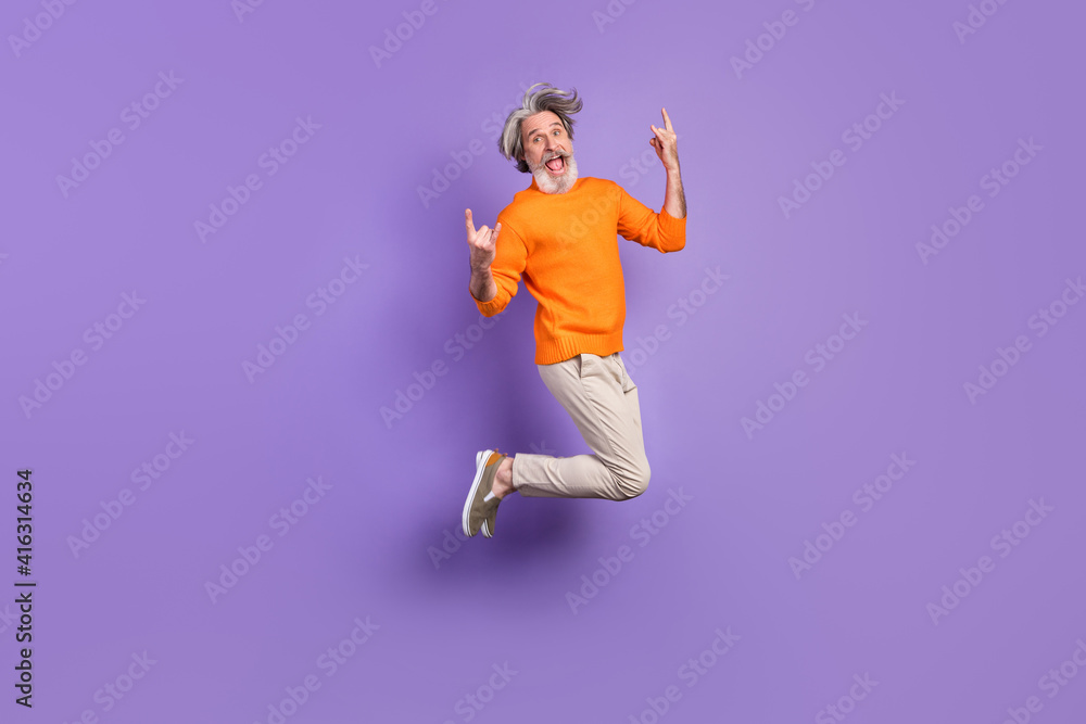 Full size photo of young crazy funky funny smiling old man jumping showing  rock'n'roll sign isolated on violet color background Stock Photo | Adobe  Stock
