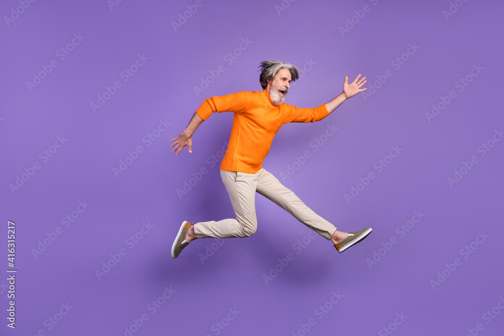 Full length profile side photo of aged man jump up wear casual outfit isolated over purple color background