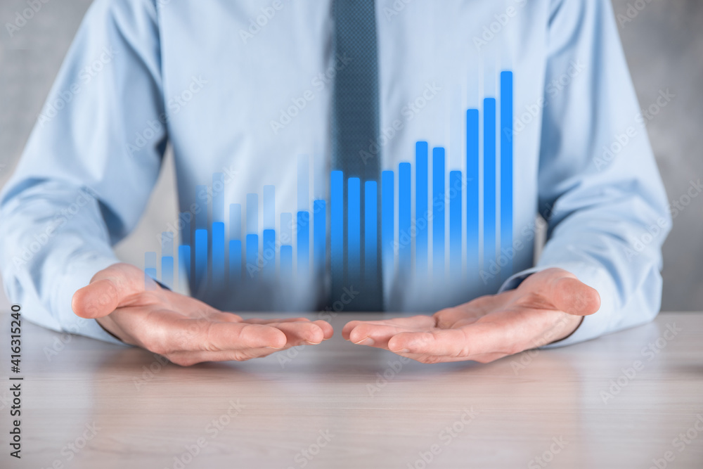Businessman man holding a graph with positive profits growth. plan graph growth and increase of chart positive indicators in his business.more profitable and growing Businessman man holding a graph with positive profits growth. plan graph growth and increase of chart positive indicators in his business.more profitable and growing