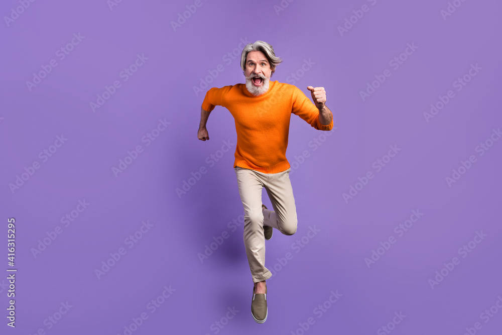 Full body photo of aged man go walk run hurry late jump wear casual outfit isolated over purple color background Full body photo of aged man go walk run hurry late jump wear casual outfit isolated over purple color background