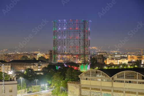 Canvas Print Night panoramic view of the city with a huge gasometer lighted up by italian col