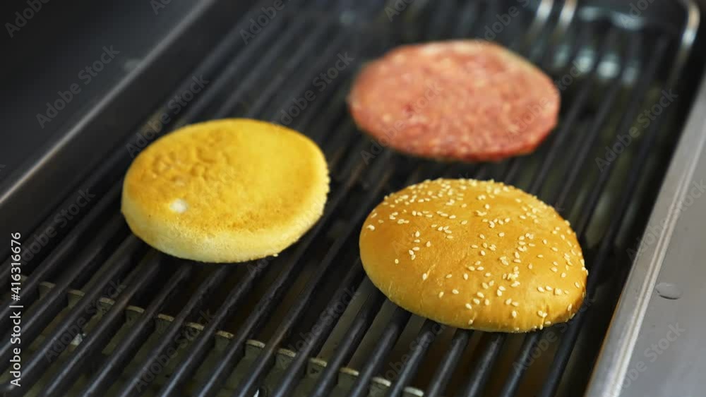 Cooking beef and pork patty for burger. Meat roasted with buns at kitchen grill. Selective video from above. Cooking beef and pork patty for burger. Meat roasted with buns at kitchen grill. Selective video from above.