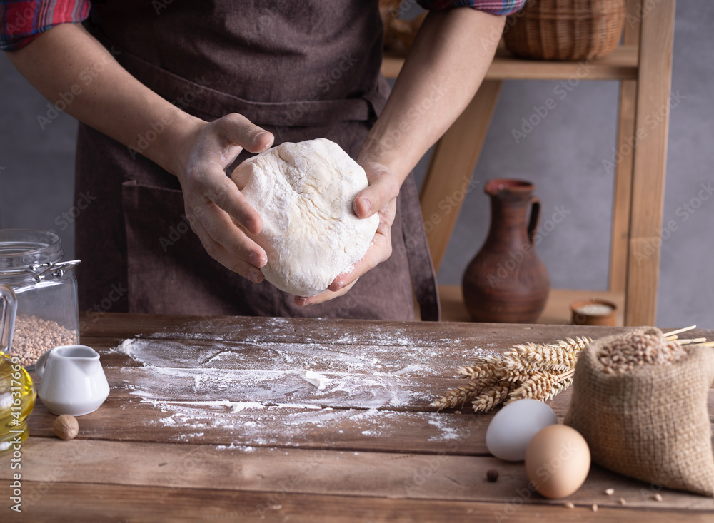 Baker man kneading dough and bakery ingredients for homemade bread cooking on table